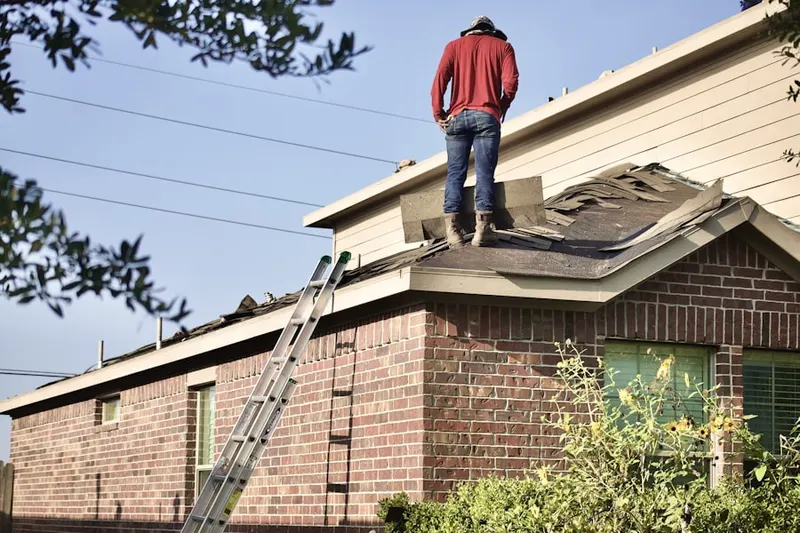 Professional roofer working on a residential roof in Ellington